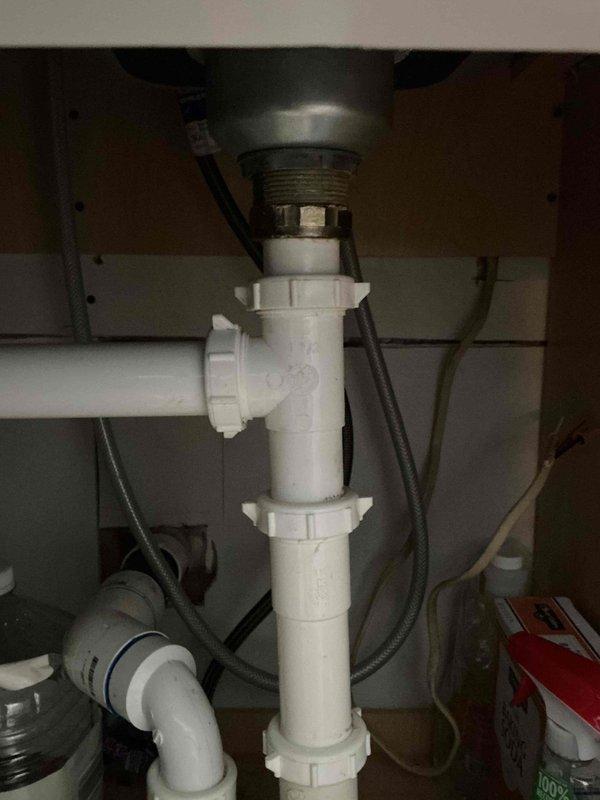 Newburgh, IN - Responded to kitchen sink drain disconnection. Upon arrival, found PVC drain pipes separated at the elbow joint beneath the sink, creating a potential flooding hazard as the water supply valve had not been shut off. Reconnected the white PVC P-trap assembly and drain tailpiece, ensuring all threaded coupling nuts were properly tightened and sealed. Tested the drain system for proper flow and verified all connections were secure with no leaks present.