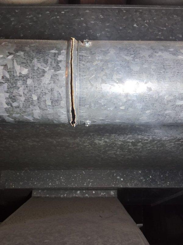 Performed scheduled Platinum Level maintenance on a 36-year-old HVAC system, replacing the 20x25x5 filter. During inspection, documented significant structural damage to the ductwork, including a 2-3 inch vertical crack in a galvanized steel pipe with signs of corrosion around the edges. Photographic evidence was collected of the damaged connection points for future reference.