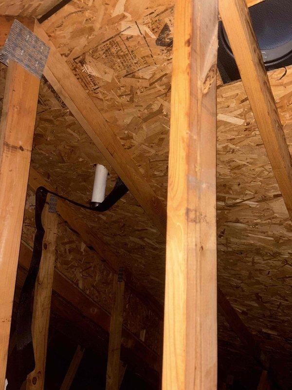 Conducted follow-up inspection of previously rerun exhaust system after customer reported water leakage into attic from cut PVC pipe left during initial service. Visual examination of the attic space confirmed presence of disconnected PVC pipe sections near the black insulated ductwork, resulting in condensation accumulation. Properly sealed and reconnected the PVC pipe to eliminate the leak source.