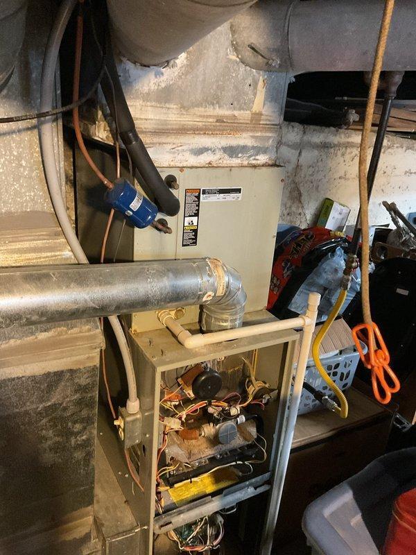 Inspected 13+ year old HVAC system that was blowing cold air instead of heat. Visual examination of the furnace revealed significant age-related wear on internal components, control board, and wiring. System requires full replacement due to deterioration of critical components and inefficient operation.