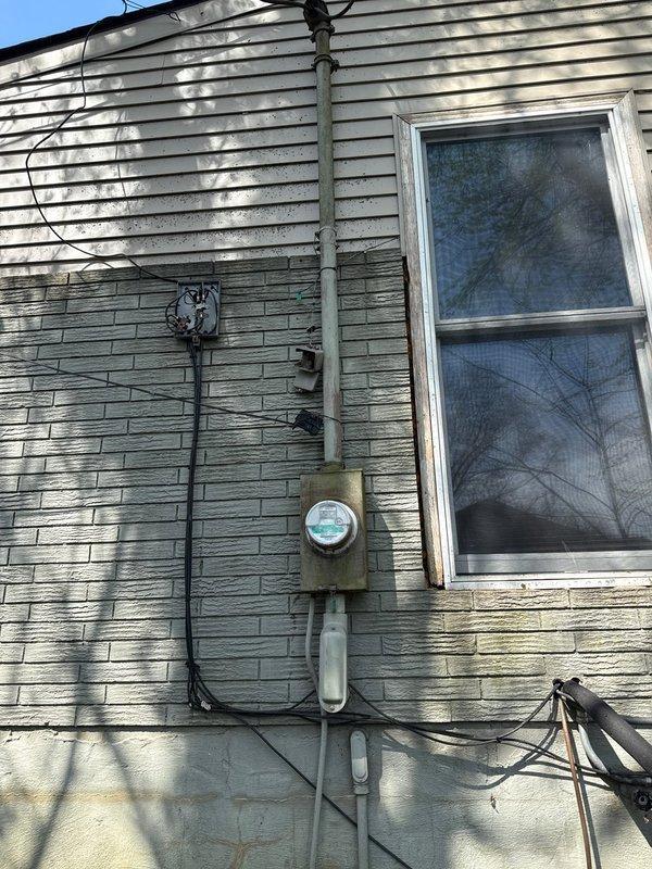 Completed comprehensive electrical estimate for main service panel replacement at residential property. Exterior assessment revealed aging meter base assembly with weathered conduit connections and deteriorated siding conditions requiring consideration during installation. Interior evaluation documented existing panel configuration with multiple circuit breakers, bundled wire connections, and proximity to plumbing infrastructure including copper pipes and PVC conduit that will need accommodation during panel upgrade. Photographed current service equipment conditions including exterior meter socket, weatherhead connections, and interior panel accessibility to provide accurate scope for complete main electrical service replacement.