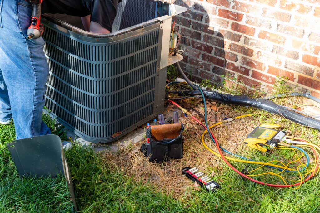 Service professional performing routine maintenance on an AC unit