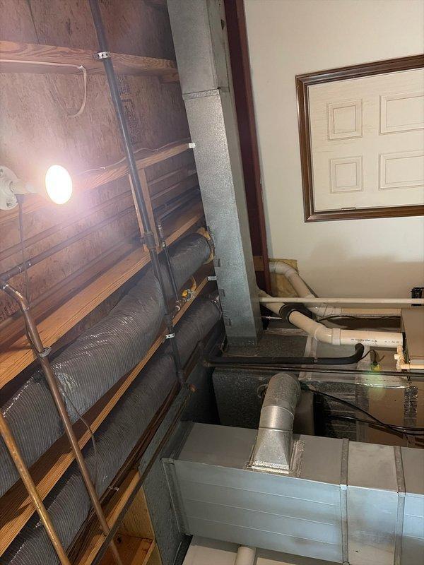 Responded to a second opinion service call for an older HVAC system, approximately 1997 model, where a previous contractor indicated the thermostat was wired incorrectly. Performed diagnostic assessment of the furnace and air distribution system located in the basement utility area, inspecting thermostat wiring, furnace operation, and ductwork configuration. Documented existing equipment conditions including the furnace unit, metallic ductwork routing, flexible ducting connections, and overall system installation for evaluation and recommendation purposes.