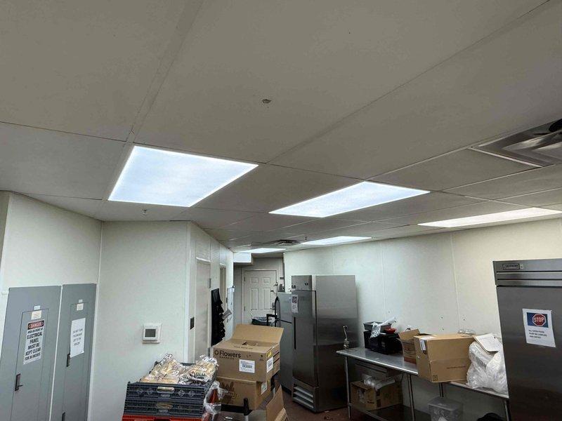 Replaced 15 fluorescent 2x4 light fixtures in commercial kitchen area during after-hours service call per customer quote. All existing fixtures were removed and new units installed in drop ceiling grid, with proper electrical connections verified and tested for functionality upon completion.