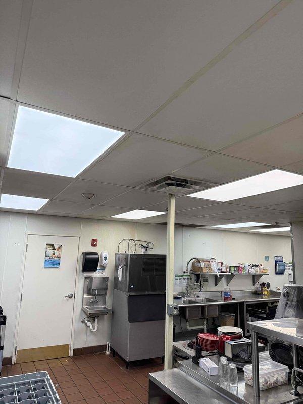Replaced 15 fluorescent 2x4 light fixtures in commercial kitchen area during after-hours service call per customer quote. All existing fixtures were removed and new units installed in drop ceiling grid, with proper electrical connections verified and tested for functionality upon completion.
