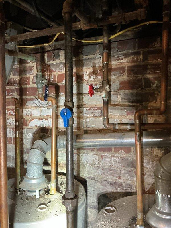 Completed annual tanked water heater flush and inspection as part of Bronze preventive maintenance plan. Performed full system evaluation including visual inspection of water heater unit, supply and discharge piping, pressure relief valve, and shut-off valves. Flushed tank to remove sediment buildup, verified proper operation of all components, and documented existing plumbing infrastructure and under-sink cabinet conditions with photographic records for maintenance history.