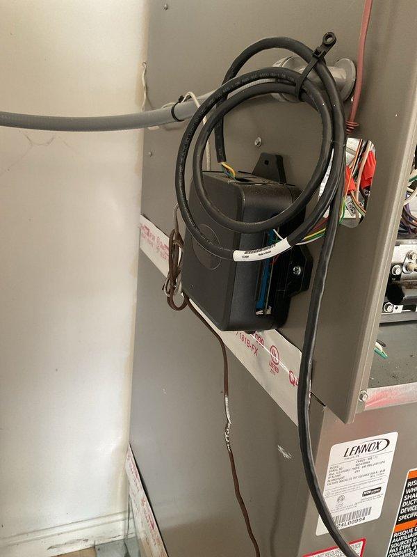Completed annual planned maintenance on one-year-old HVAC system including inspection of electrical controls, wiring connections, and associated mechanical components. Verified proper operation of water heater system, examined manufacturer labels and compliance information, and documented equipment condition with photos showing control box assembly with secured wiring, cable management, and State Industries 50-gallon natural gas water heater unit in serviceable condition.