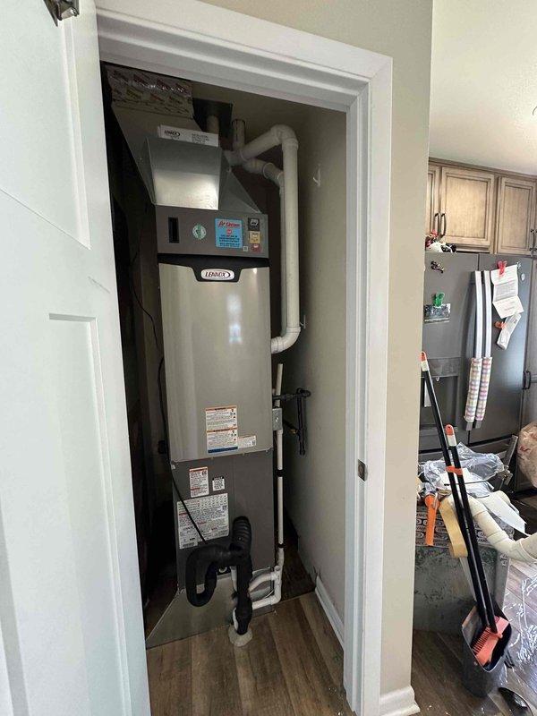 Completed installation of 2-ton, 18 SEER, 99% AFUE Lennox heating and cooling system in residential utility closet, including relocation of outdoor condensing unit approximately 10 feet from original position. System was properly charged, tested with manifold gauges confirming operating pressures within manufacturer specifications, and all components verified operational with appropriate airflow and temperature differentials.