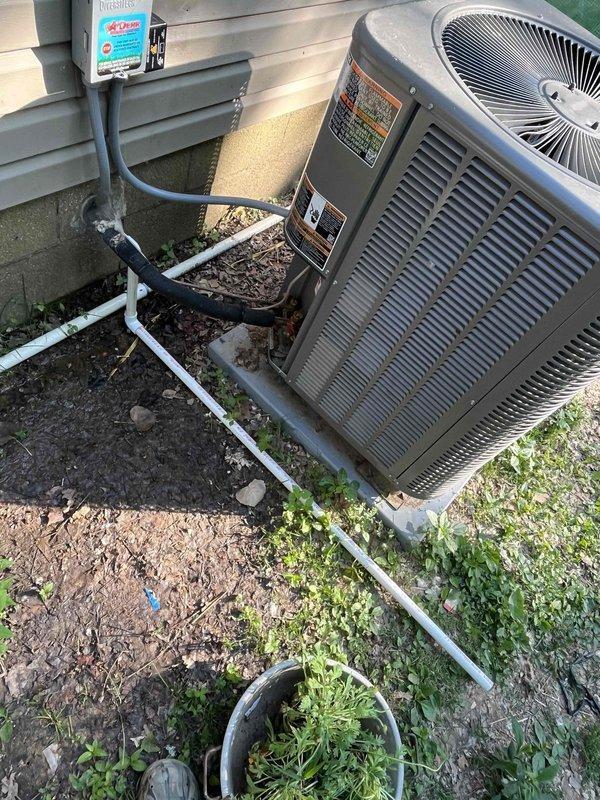 Boonville, IN - Responded to service call regarding musty odor and continuous condensate drainage from residential air conditioning system. Upon inspection, found AC condenser unit operational with refrigerant lines and condensate drain lines in place. Photographed equipment installation showing unit positioned on concrete pad with PVC drainage routing along foundation. Assessed drainage concerns related to constant water discharge near house perimeter and investigated source of wet towel odor potentially originating from condensate system or indoor evaporator coil.